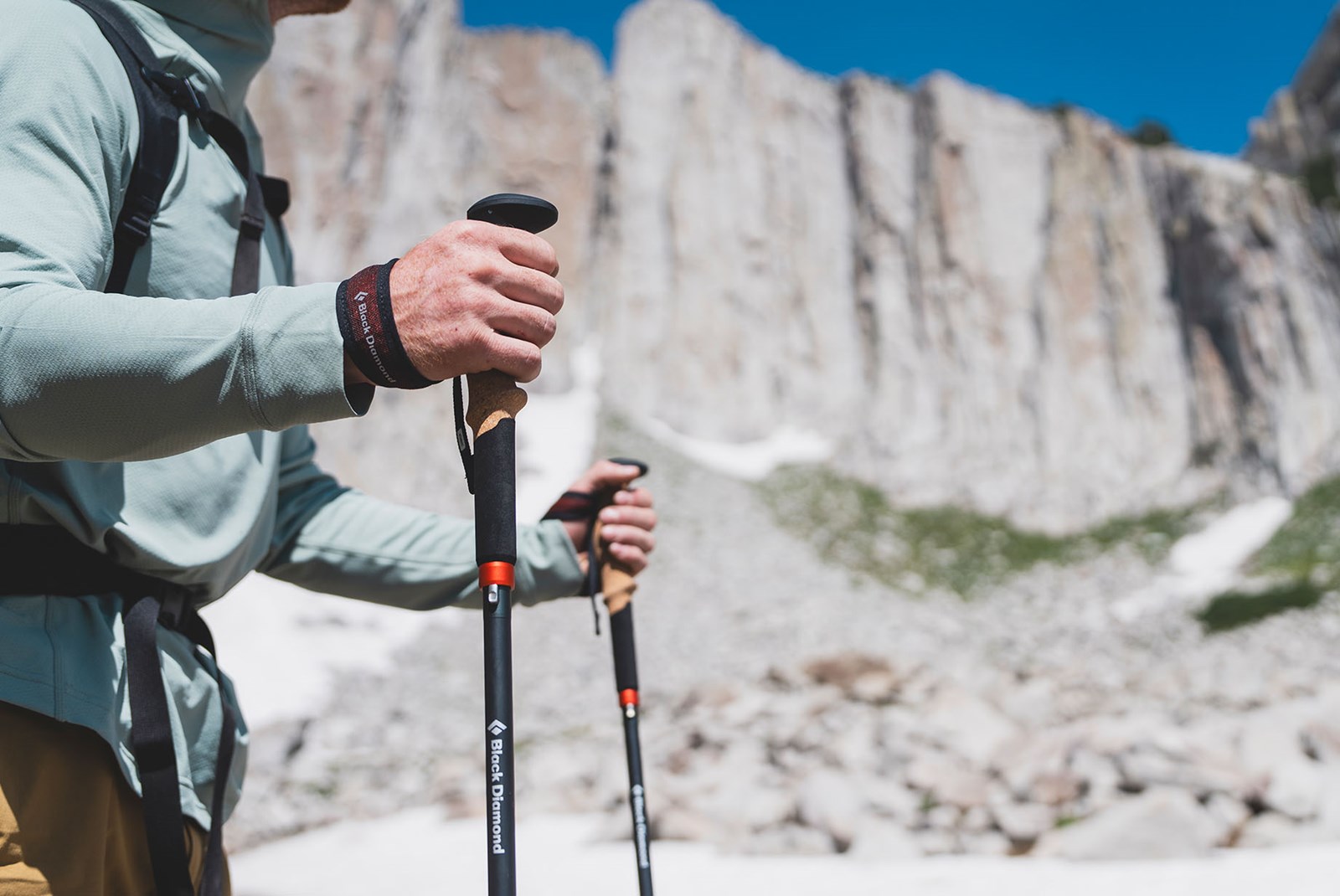 Nærbillede af en person der holder sine vandrestave i remmen.