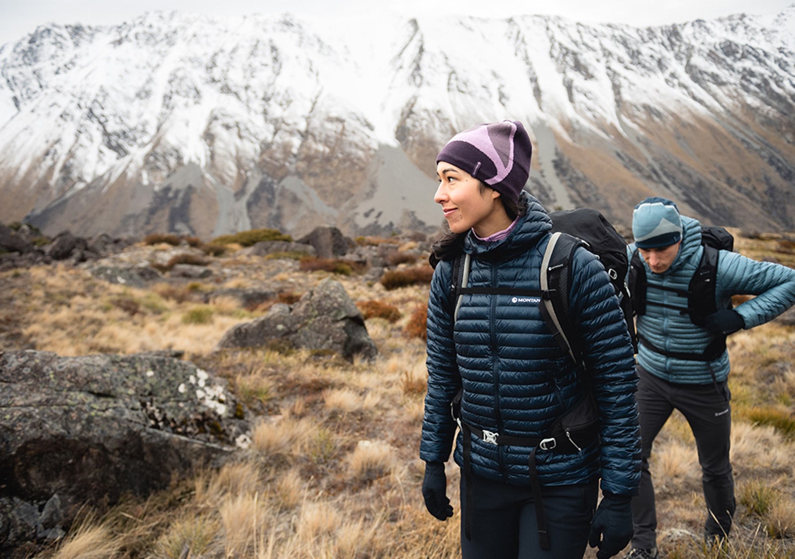 Par går i dunjakker i bjergene