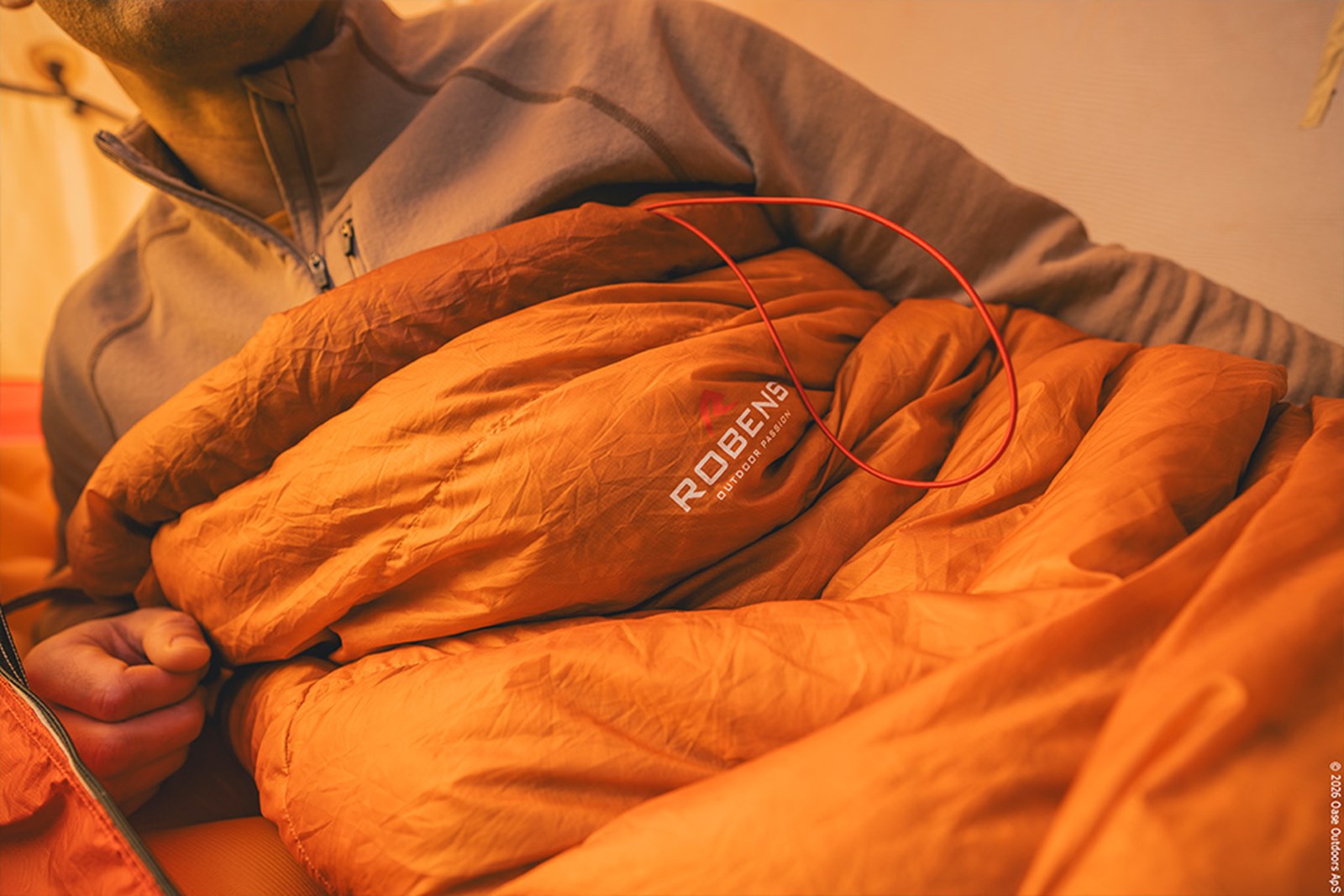 Mand ligger i sin sovepose