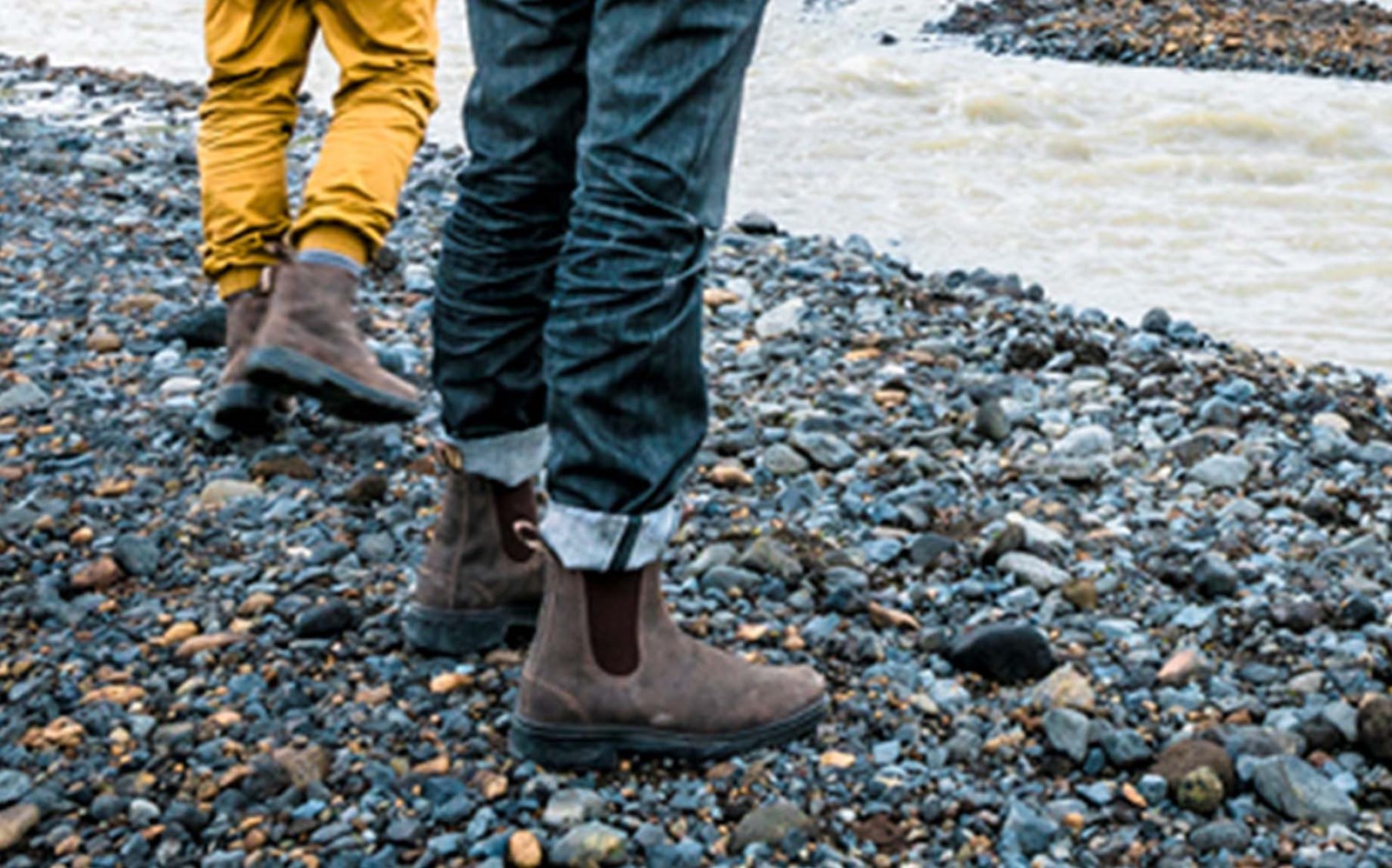 To personer i Blundstone støvler ved vandet.