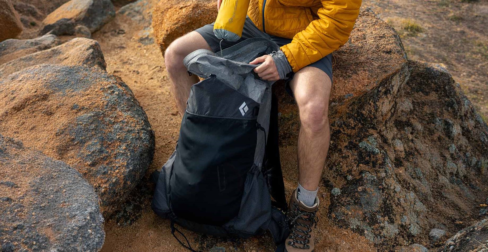 Person der pakker grej ned i en Black diamond Beta Light 45 Backpack.