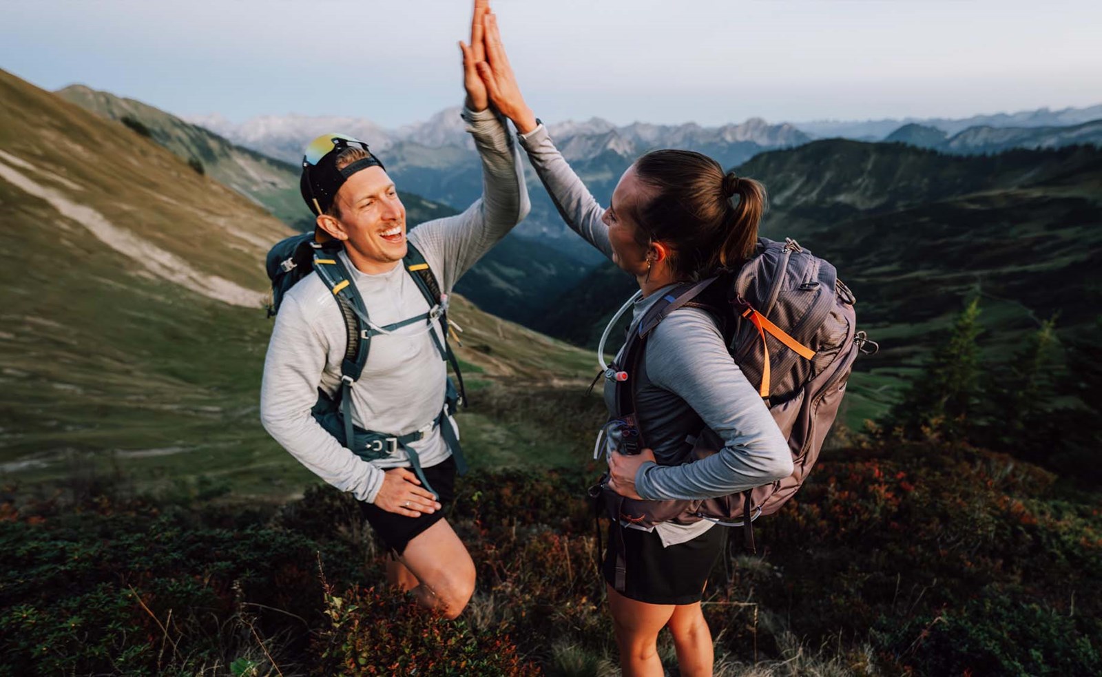 To personer med rygsække der giver hinanden en highfive.